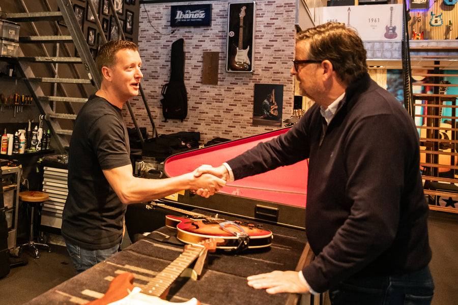 Handdruk aan de balie bij het inruilen van een gitaar